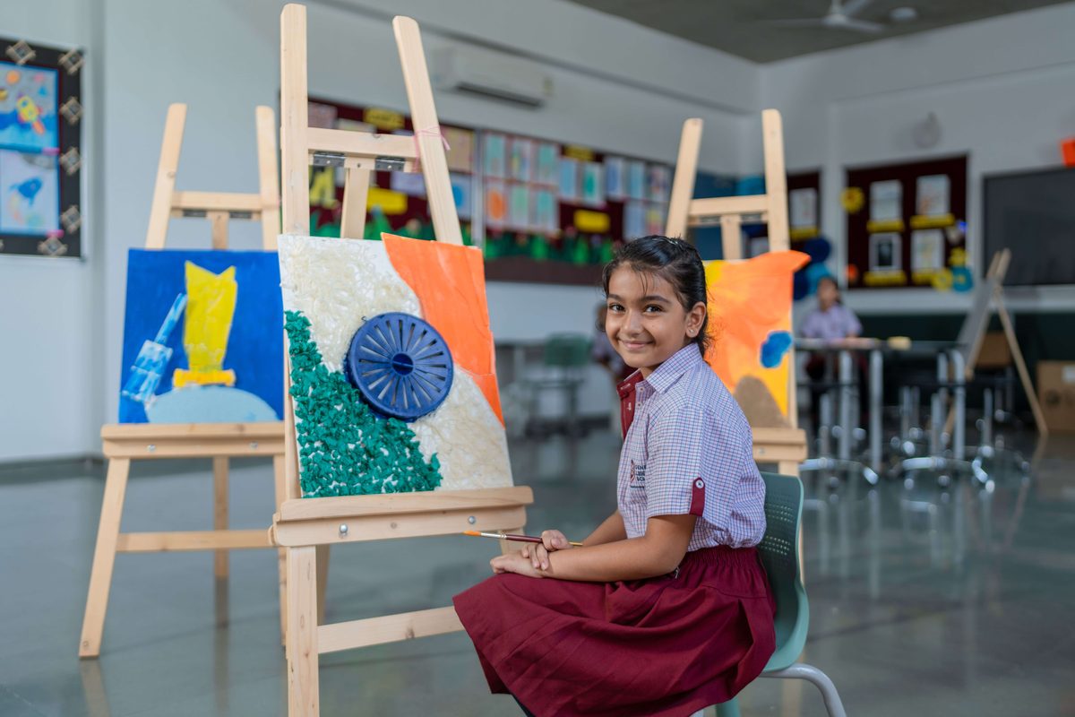 Student painting at an easel in the school art room