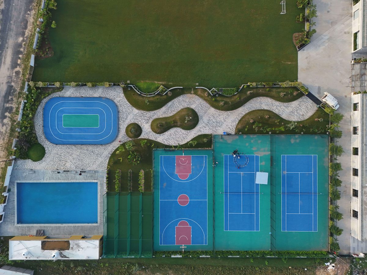Aerial view of the campus sports complex with running track, swimming pool and courts